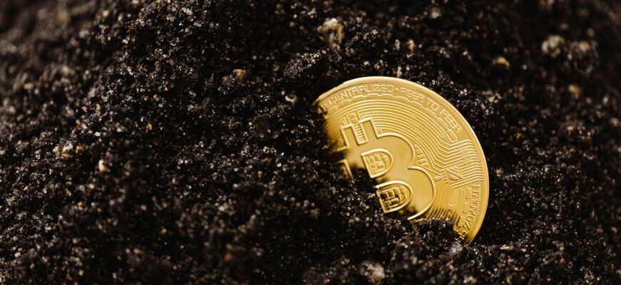 Golden Bitcoin partially buried in dark soil, symbolizing digital currency growth.