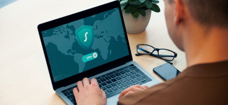 person using macbook pro on white table