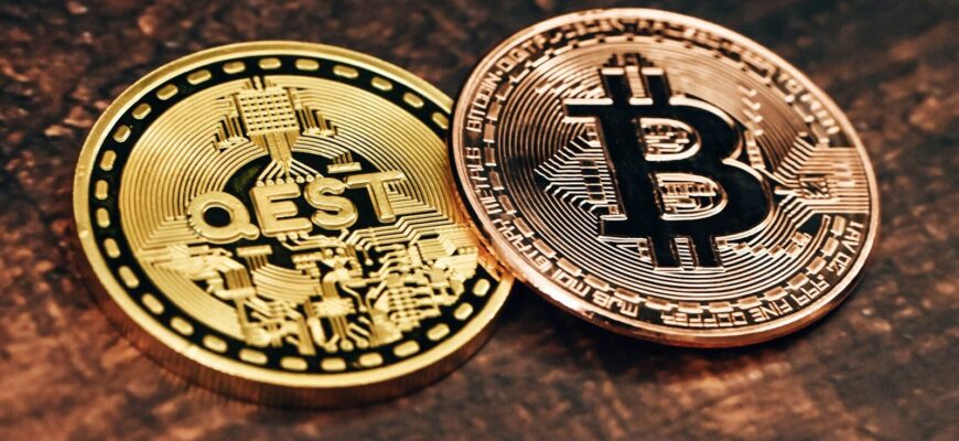 two gold and silver bitcoins sitting on a table